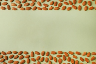 Photo of Composition with organic almond nuts and space for text on color background, top view