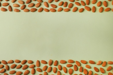 Composition with organic almond nuts and space for text on color background, top view