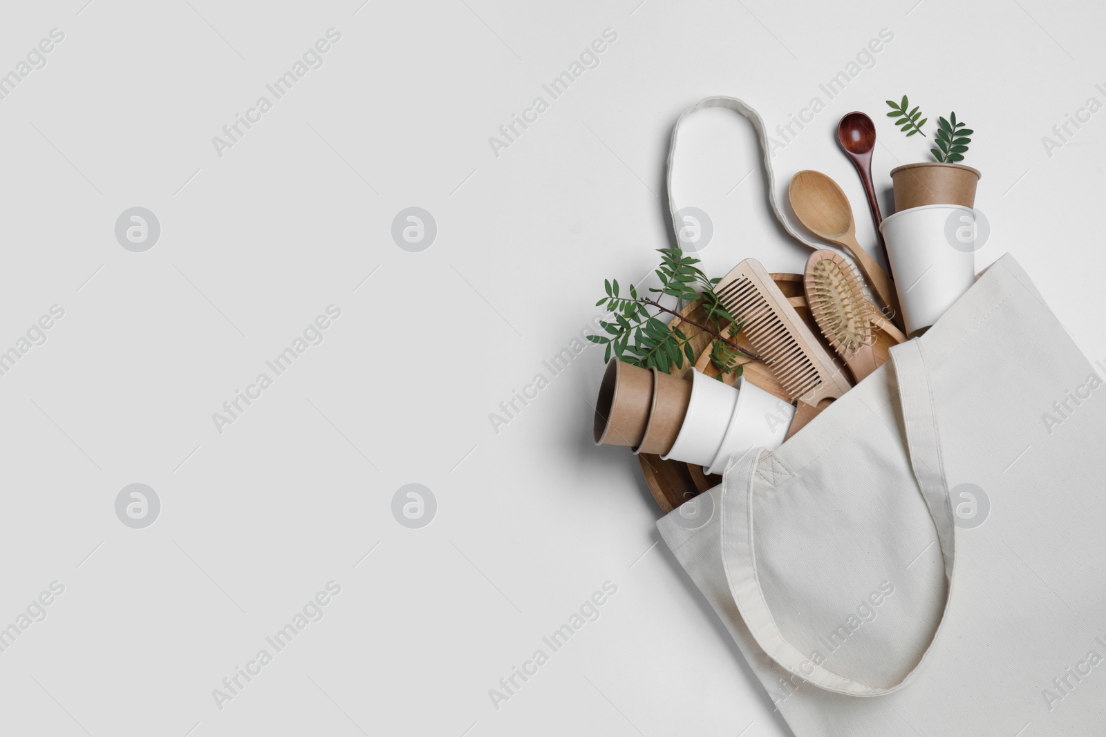 Photo of Eco bag with different disposable items on white background, top view and space for text. Recycling concept