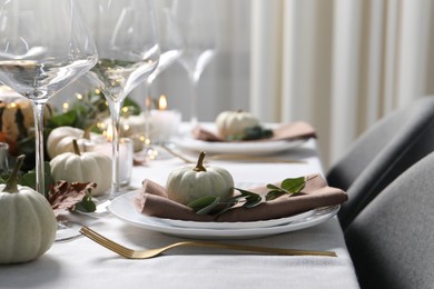 Beautiful autumn table setting. Plates, cutlery, glasses, pumpkins and floral decor