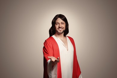 Jesus Christ reaching out his hand on beige background