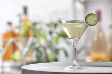Photo of Glass of tasty cucumber martini on table indoors, space for text