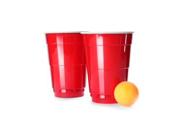 Red plastic cups and ball for beer pong on white background