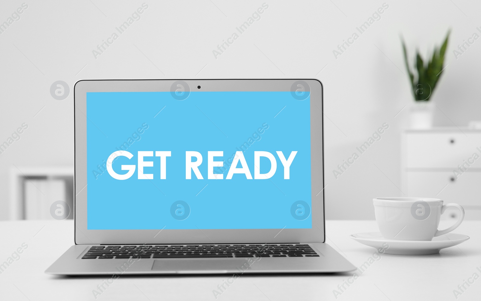 Image of Modern laptop with phrase Get Ready on screen in office
