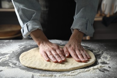 Photo of Woman making pizza dough at table, closeup