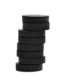 Photo of Stack of black pills on white background. Medical treatment