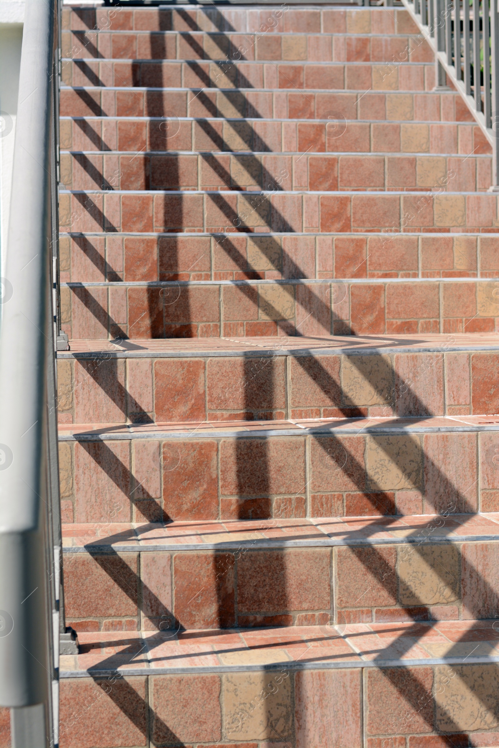 Photo of Beautiful tiled stairs with metal railings outdoors