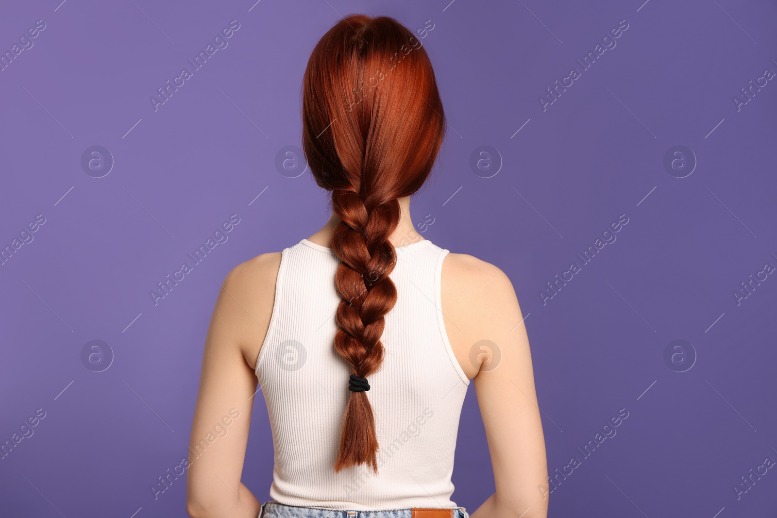Photo of Woman with red dyed braided hair on purple background, back view