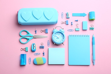 Photo of Light blue school stationery on pink background, flat lay
