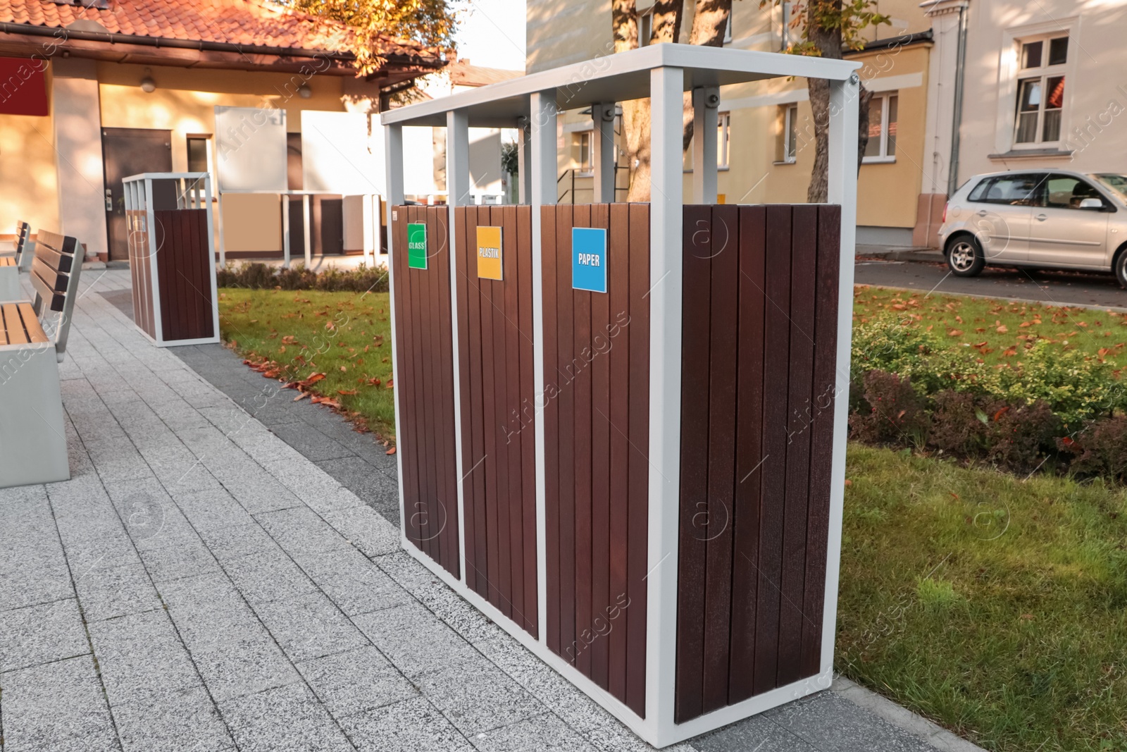 Photo of Different sorting bins for waste recycling on city street outdoors