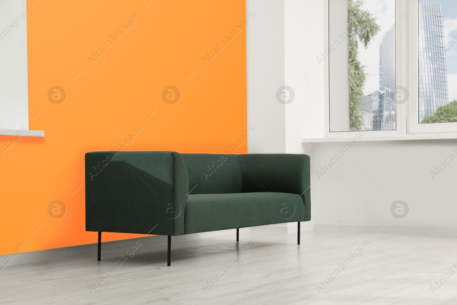 Photo of Beautiful interior with sofa near orange wall