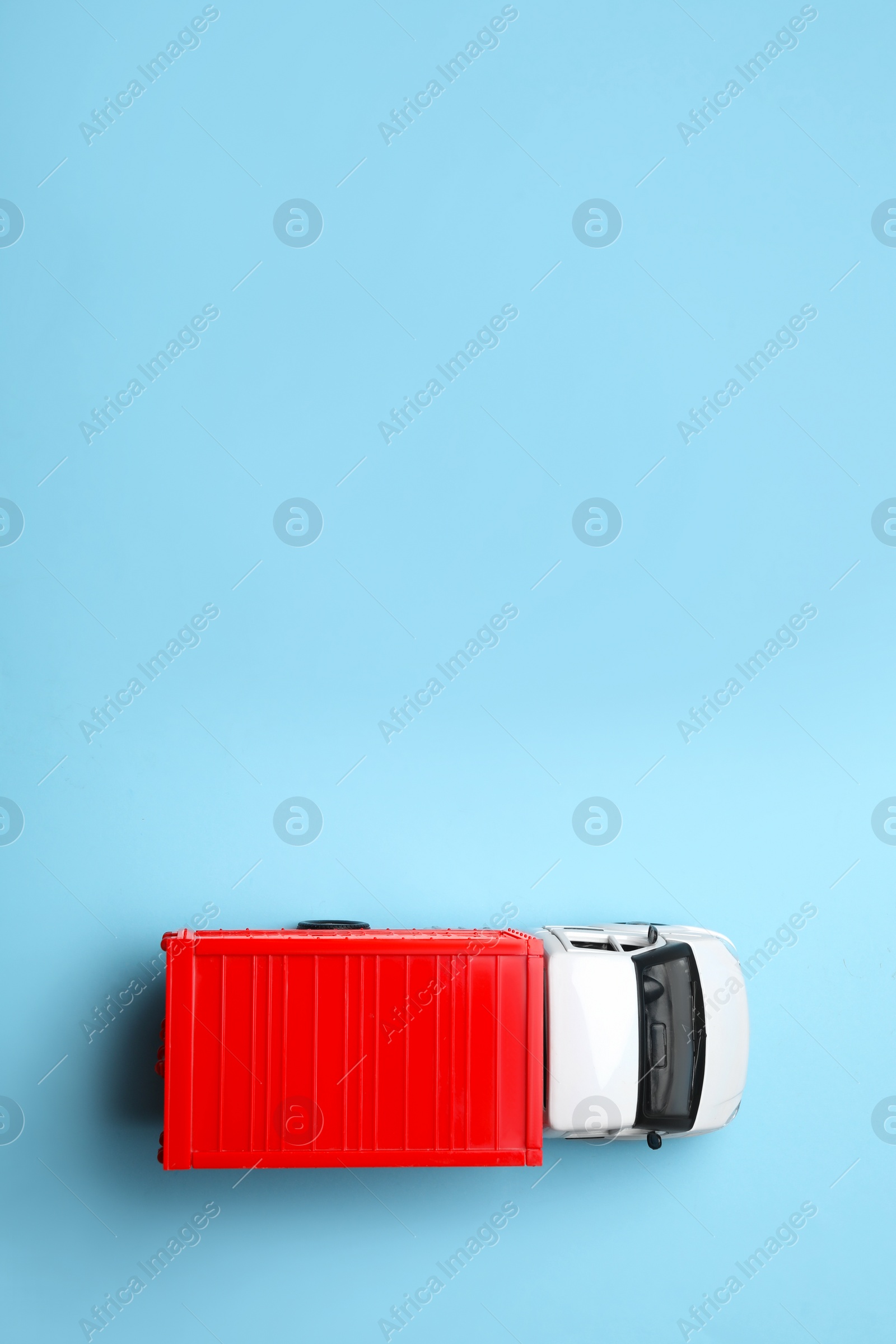 Photo of Top view of toy truck on blue background, space for text. Logistics and wholesale concept