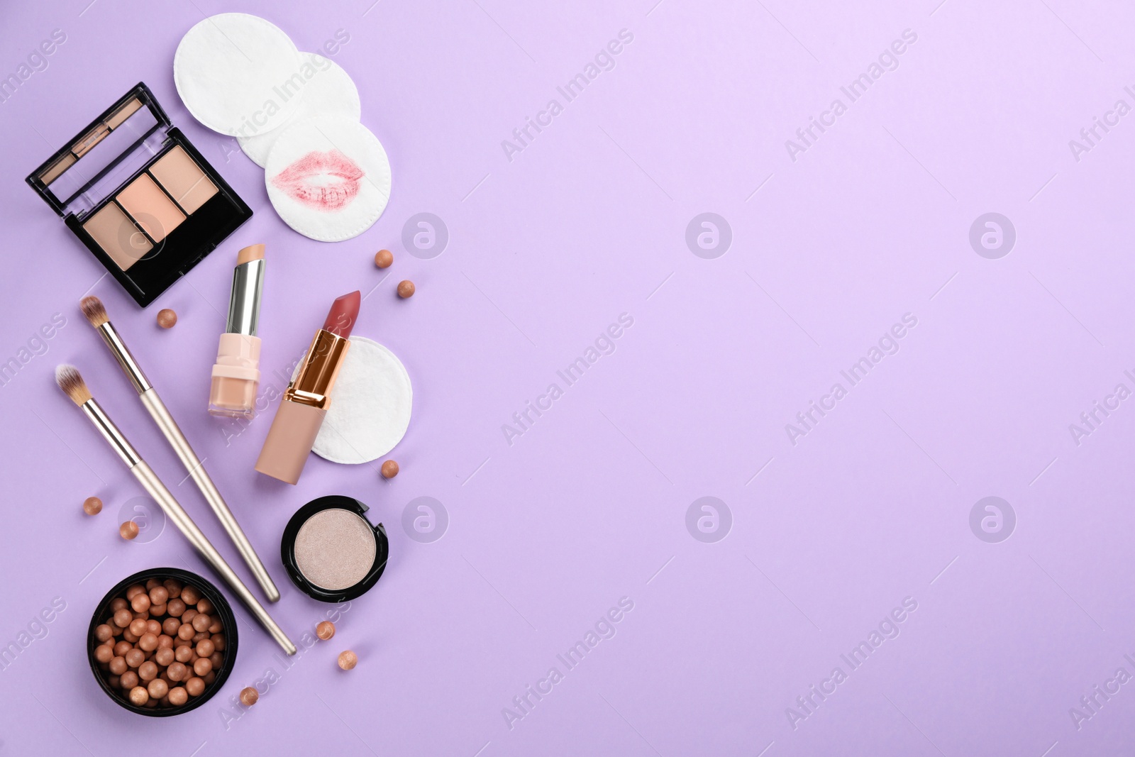 Photo of Dirty cotton pads and cosmetic products on lilac background, flat lay. Space for text