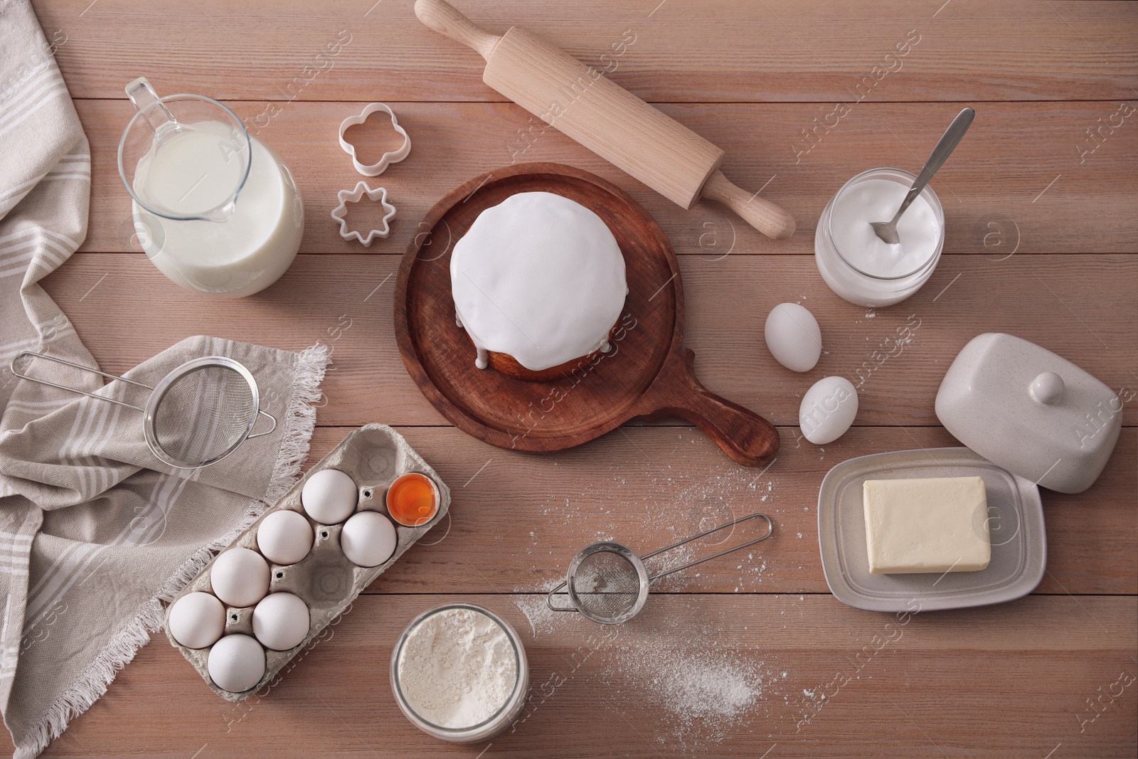 Photo of Flat lay composition with traditional Easter cake and ingredients on wooden table