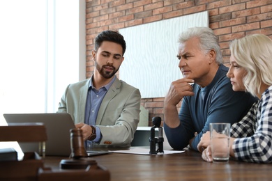 Male notary working with mature couple in office