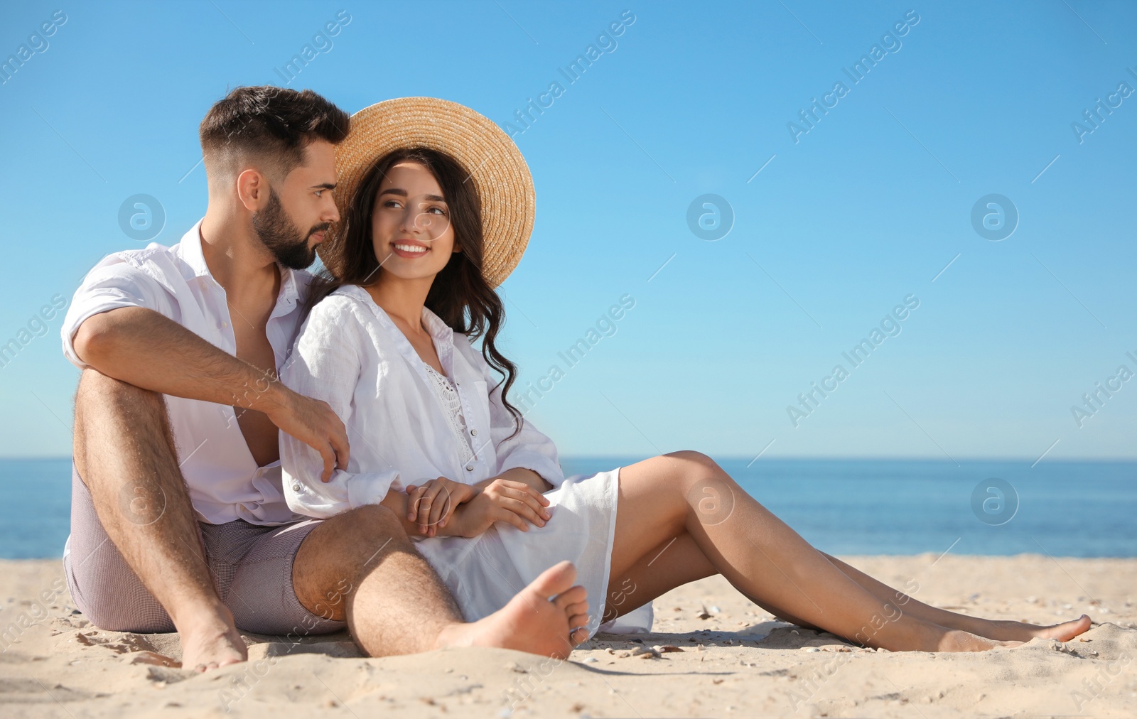 Photo of Happy young couple on beach near sea. Honeymoon trip