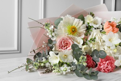 Photo of Bouquet of beautiful flowers on white wooden table, closeup