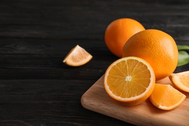 Photo of Fresh juicy oranges on wooden table. Space for text