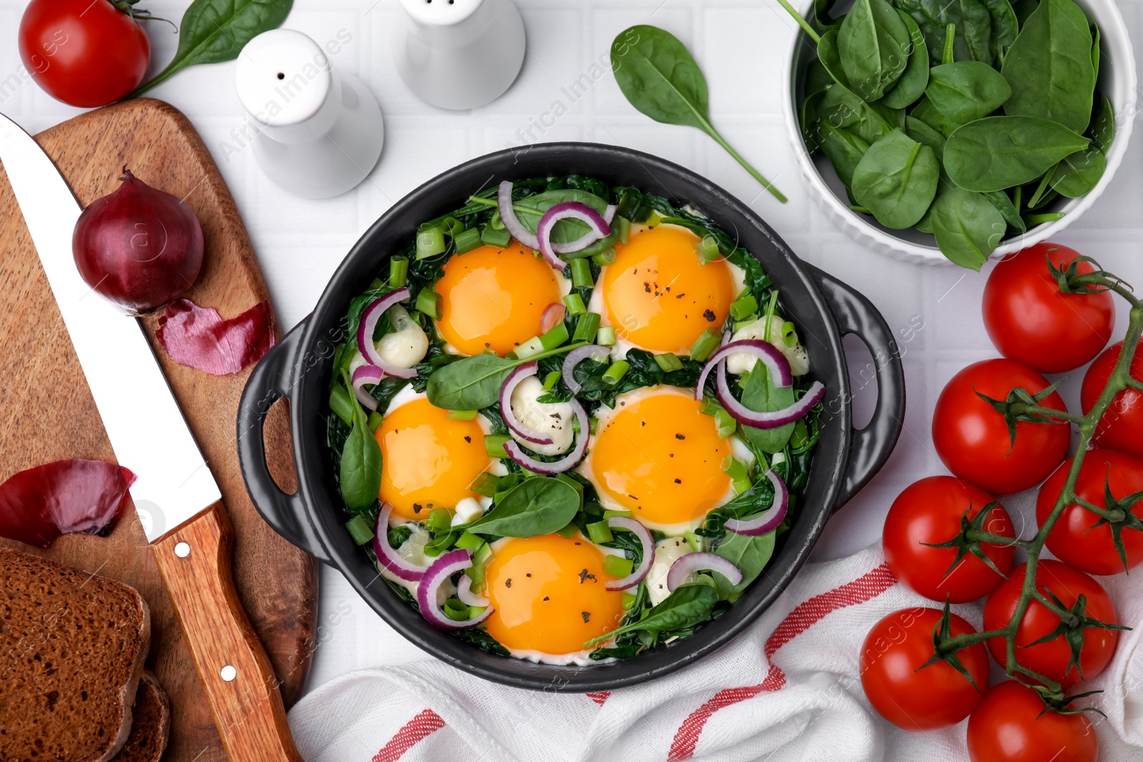 Photo of Flat lay composition with tasty green Shakshouka and ingredients on white table