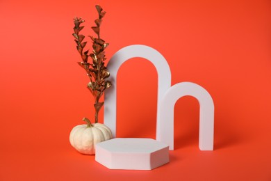 Autumn presentation for product. White geometric figures, pumpkin and golden branch with leaves on dark orange background