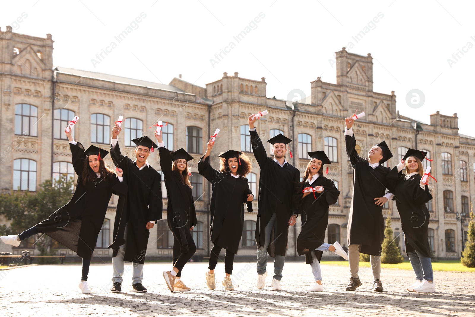 Photo of Happy students with diplomas outdoors. Graduation ceremony