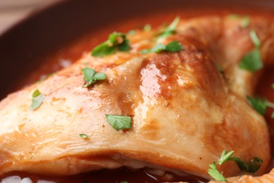 Photo of Tasty cooked rabbit meat with sauce and parsley, closeup