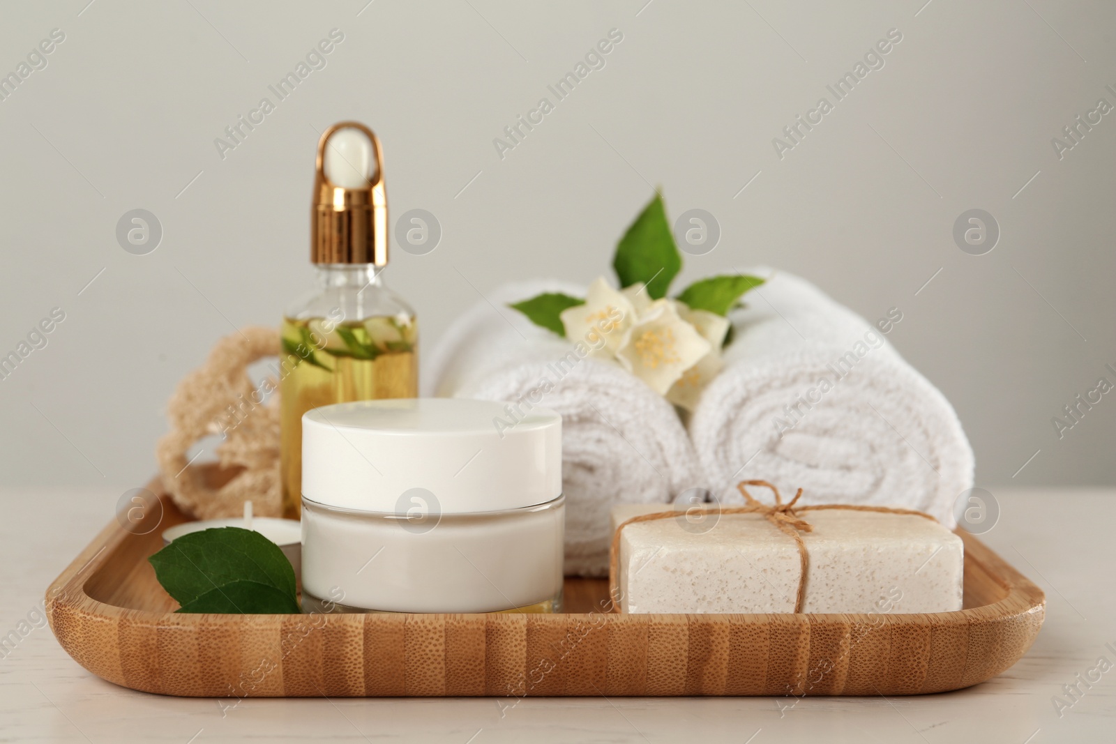 Photo of Composition with beautiful jasmine flowers and skin care products on white table