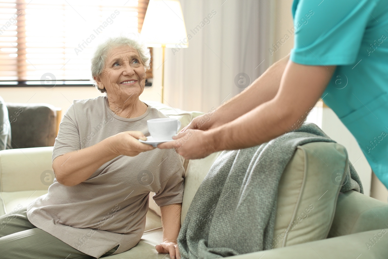 Photo of Medical worker taking care of elderly woman in geriatric hospice