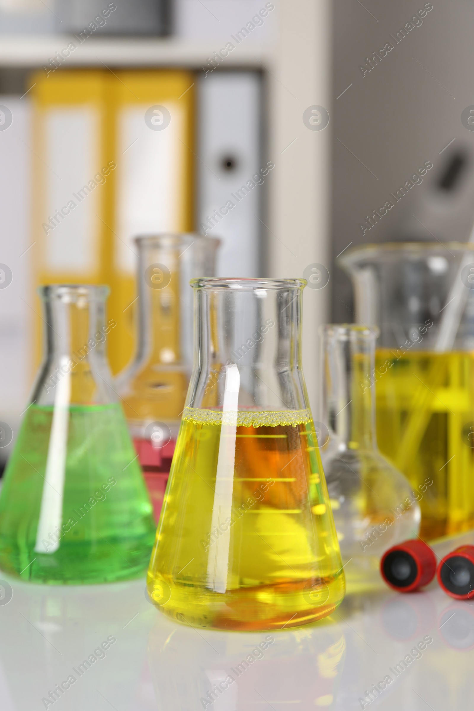 Photo of Laboratory analysis. Different glassware with liquids on white table indoors