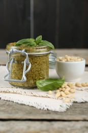 Delicious pesto sauce, pine nuts and basil leaves on wooden table