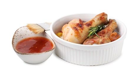 Photo of Marinade, basting brush, roasted chicken drumsticks, rosemary and tomatoes isolated on white