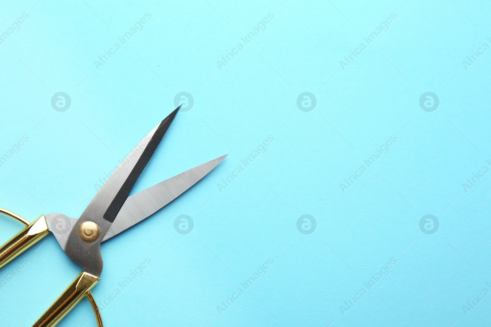 Photo of Pair of sharp scissors on color background, top view. Space for text