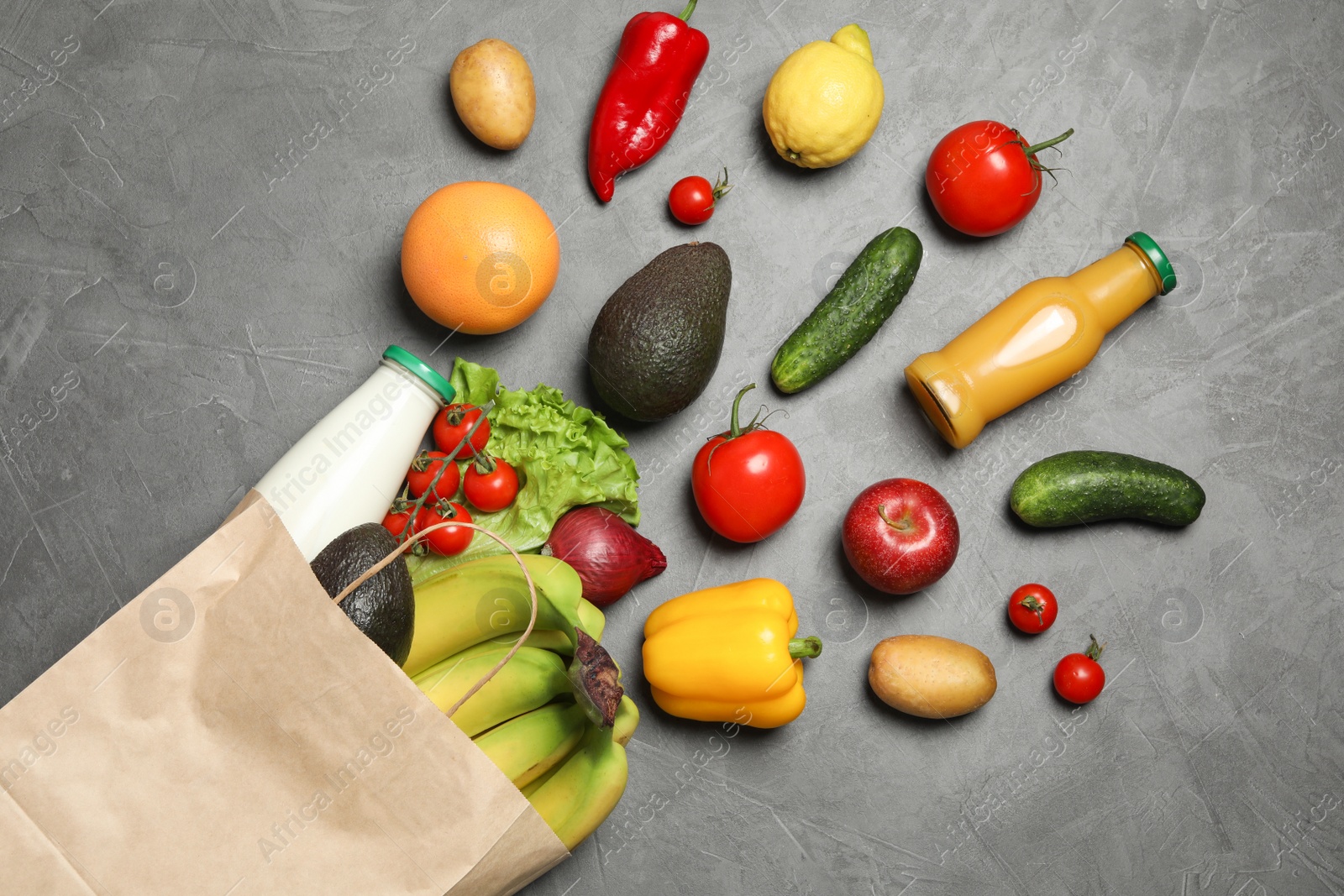 Photo of Paper bag with groceries on grey background, flat lay