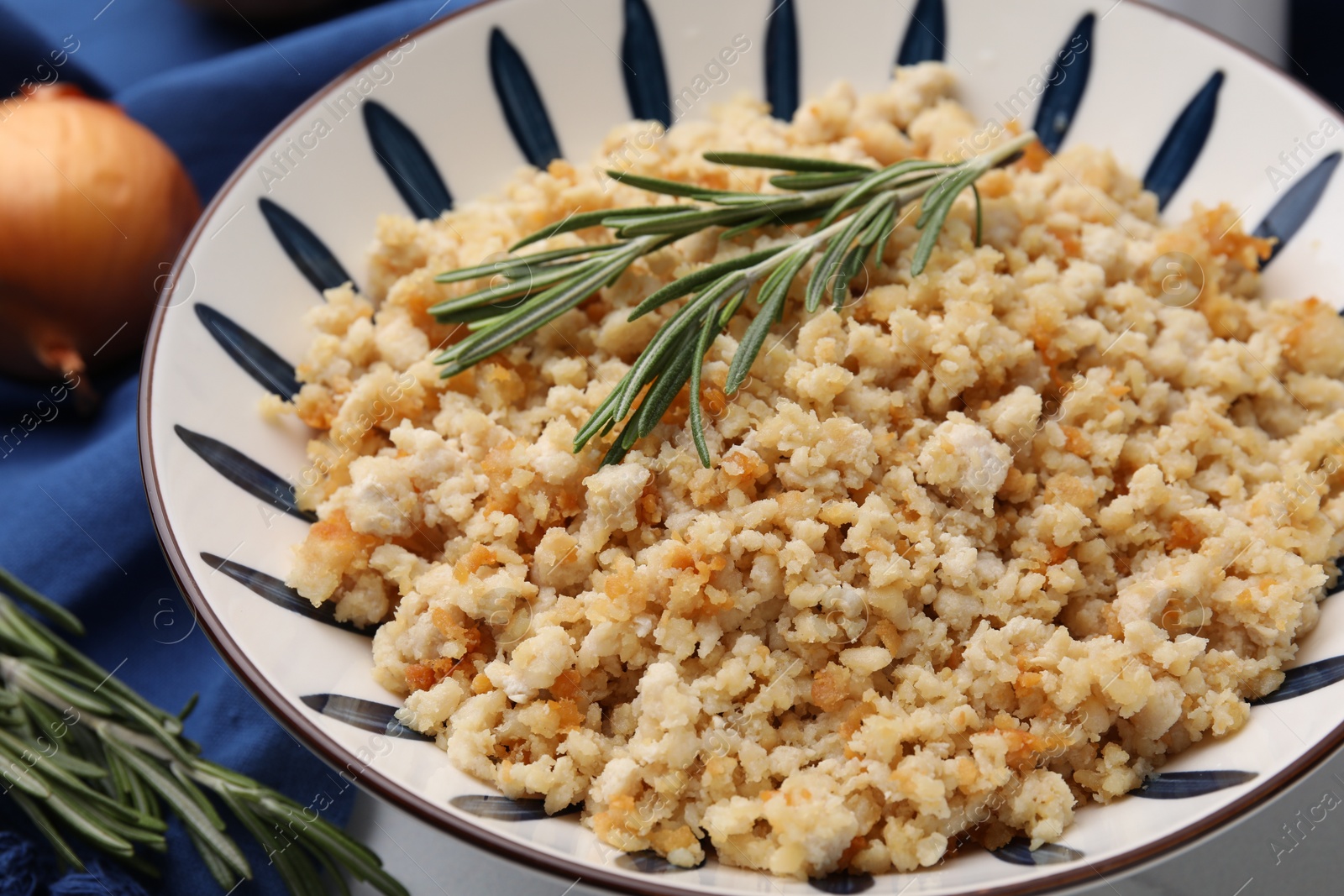 Photo of Fried ground meat in bowl and rosemary on table, closeup