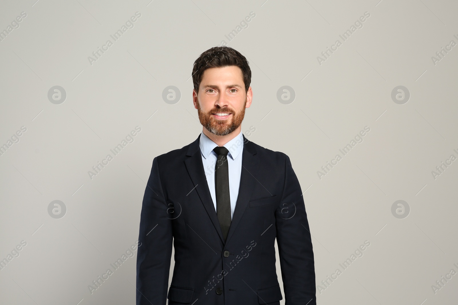 Photo of Handsome real estate agent in nice suit on grey background