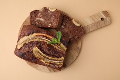 Delicious banana bread with mint on beige background, top view
