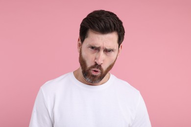 Photo of Portrait of surprised man on pink background