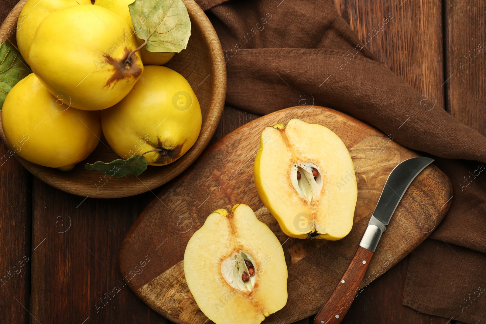 Photo of Tasty ripe quince fruits and knife on wooden table, flat lay
