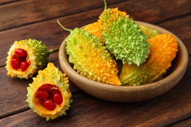 Photo of Fresh bitter melons on wooden table, closeup