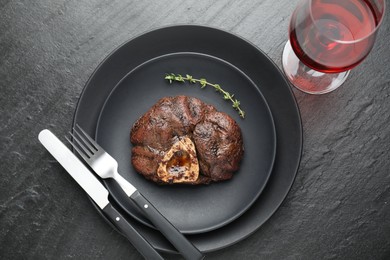 Photo of Tasty grilled beef meat served on black table, flat lay