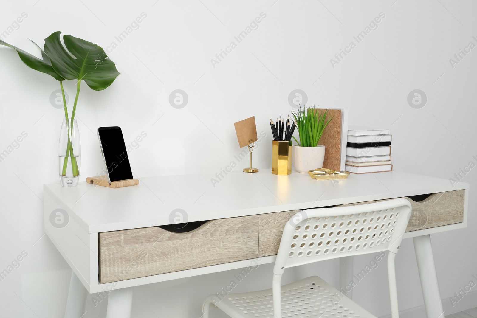 Photo of Comfortable workplace with white desk near wall