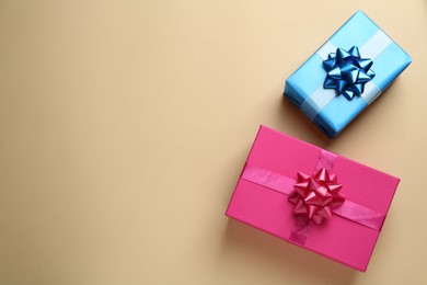 Photo of Colorful gift boxes on beige background, flat lay. Space for text