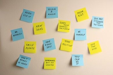 Photo of Paper notes with life-affirming phrases on white wall