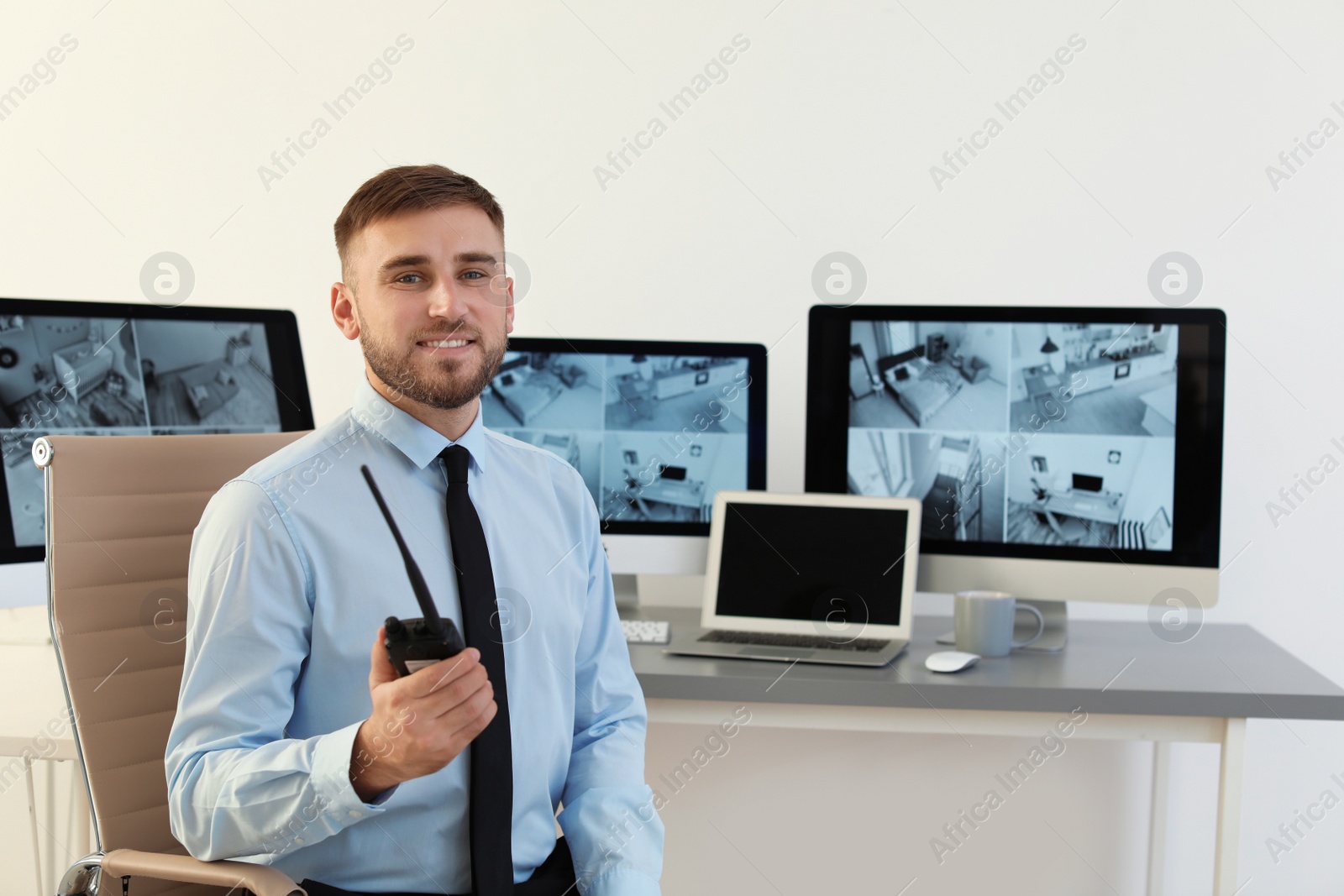 Photo of Male security guard with portable transmitter at workplace