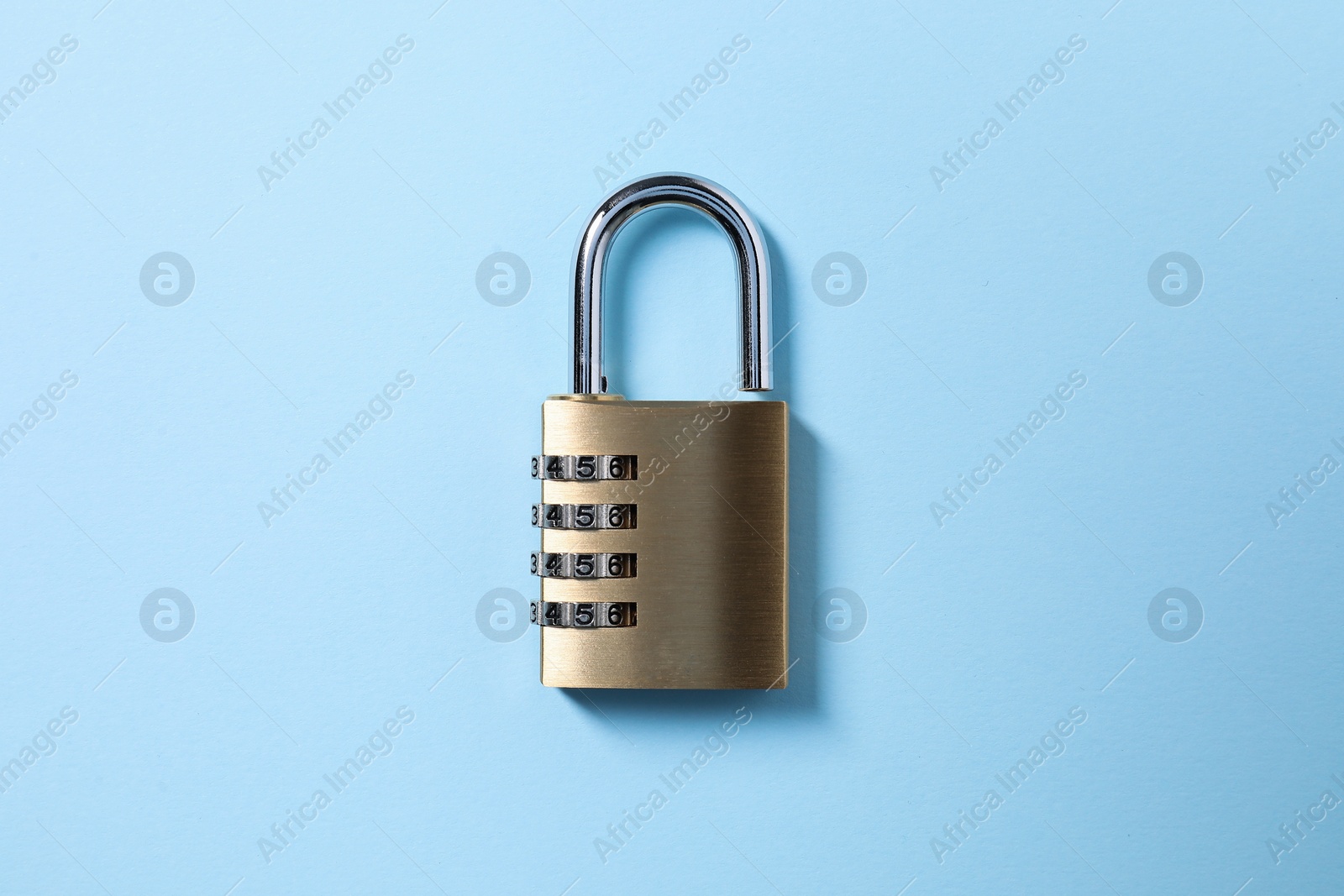 Photo of Steel combination padlock on light blue background, top view