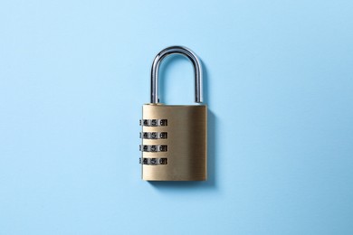 Steel combination padlock on light blue background, top view