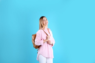 Teenage girl with backpack on color background