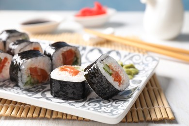 Photo of Tasty sushi rolls with wasabi served on table, closeup