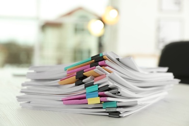 Stack of documents with paper clips on office table