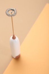 White milk frother wand on color background, closeup. Space for text